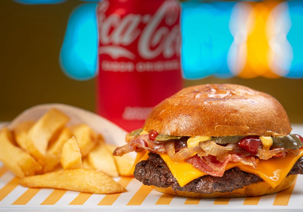 Imagen principal - Una hamburguesa y unas patatas, listas para un cliente; un cocinero preparando las hamburguesas con carne recién recibida y unas patatas.