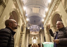 El arquitecto y el rector del templo en la iglesia donde se observa la malla que cubre la nave central.