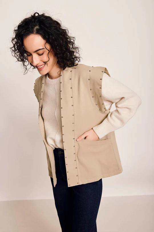 Imagen principal - Arriba, chaleco de tachas beige de Algo Bonito, por 49,99 euros. A la izquierda, chaleco con textura con cuello polo a juego con el pantalón de Mango por 12,99 euros. A la derecha, chaleco bordado de Samsara, por 37,50 euros. 