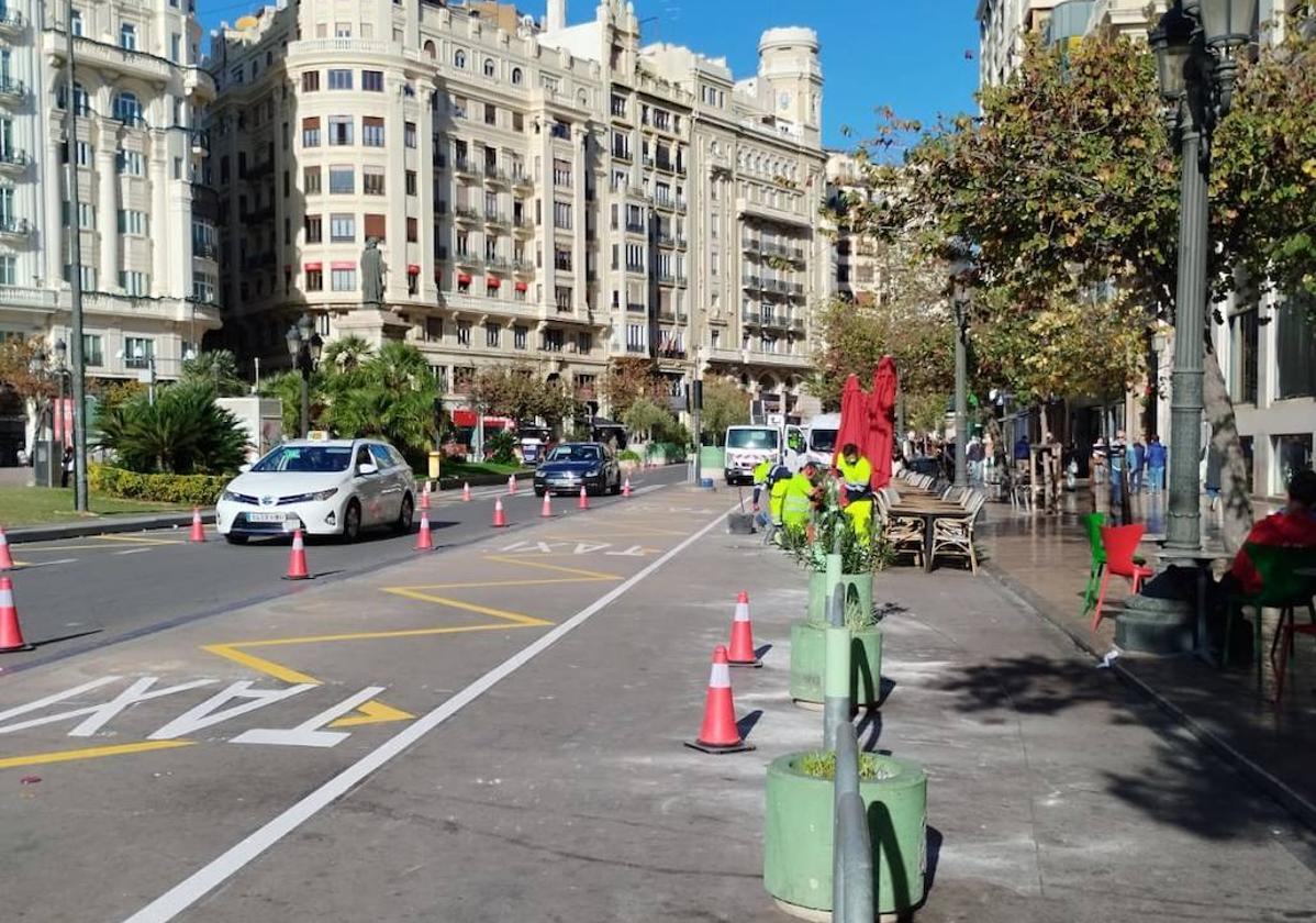 Operarios trabajan en el cambio de acera de la parada de taxis en la plaza del Ayuntamiento.