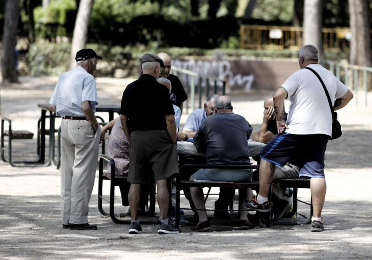 Varios pensionistas juegan al dominó en un parque