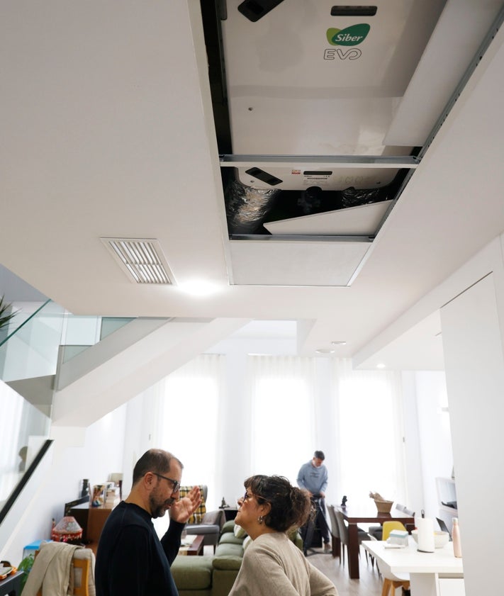 Imagen secundaria 2 - Fachada de la vivienda, su parte posterior (donde se aprecia que consta de baja más dos alturas) y Manuela y Joan bajo el llamado 'pulmón' de su hogar: el mecanismo que garantiza el perfecto funcionamiento del método passivhaus.