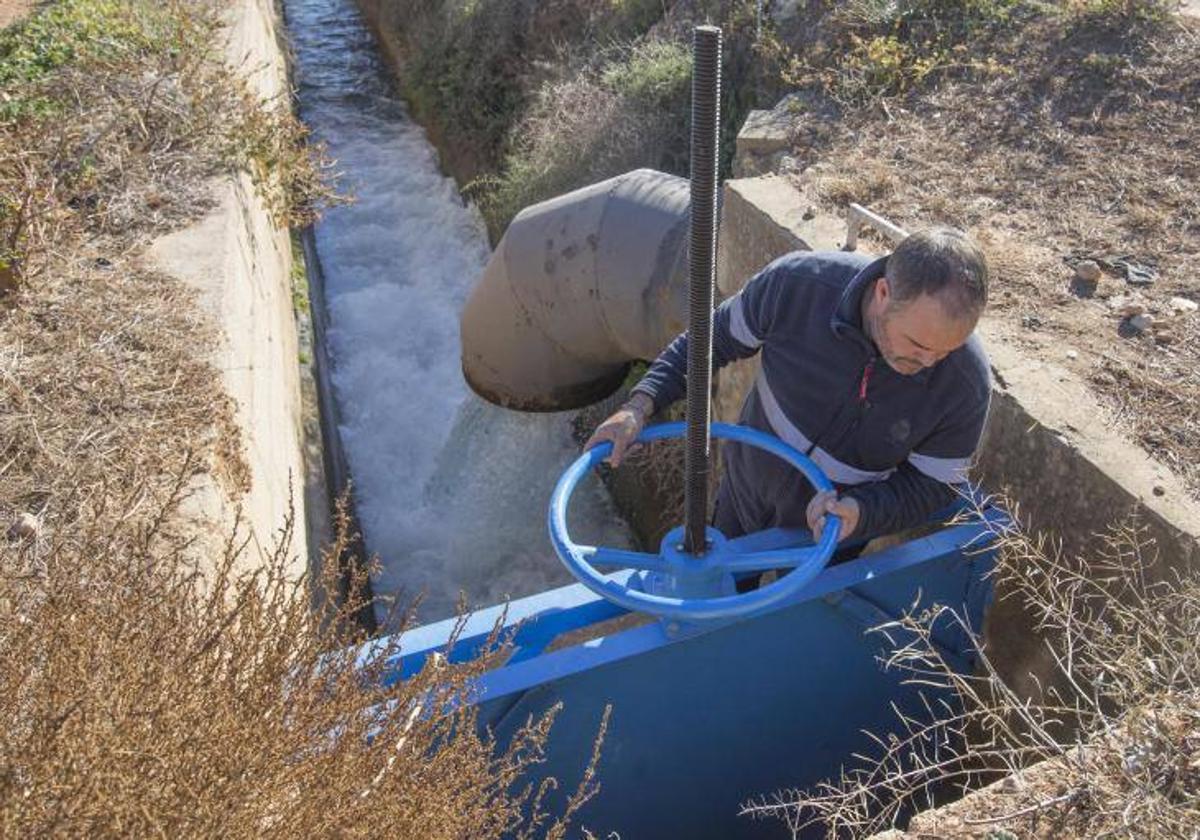 Celestino, el acequiero de la Acequia Real del Júcar, abre una de las compuertas que suministró este lunes más agua a la Albufera.