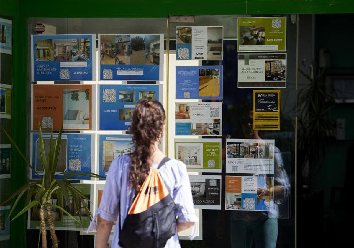 Una mujer, frente al escaparate de una inmobiliaria en Valencia.