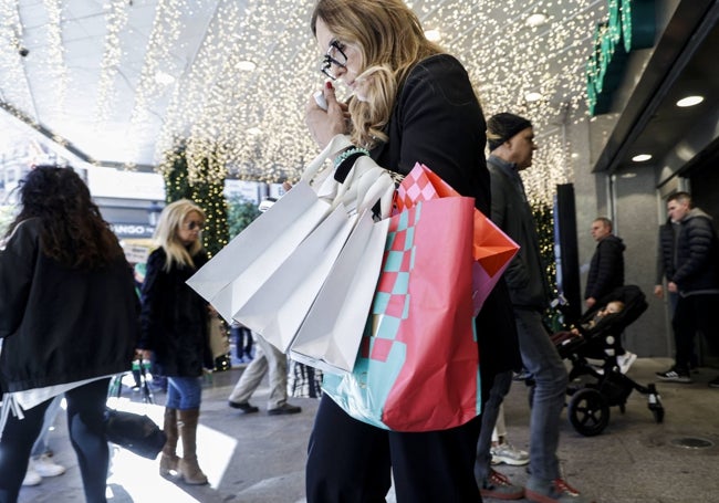 Una mujer con un puñado de bolsas tras sus compras.