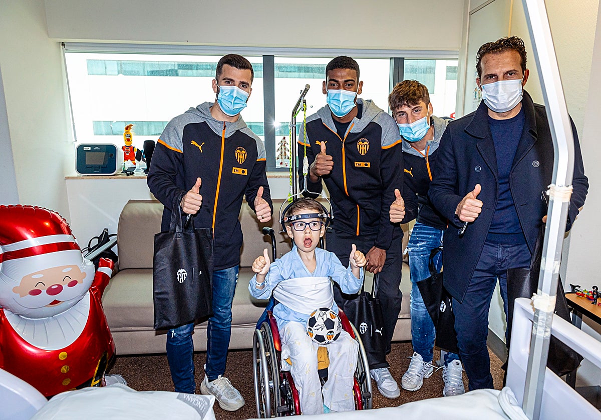 Gayà, Mosquera, Canós y Baraja junto a un niño hospitalizado.