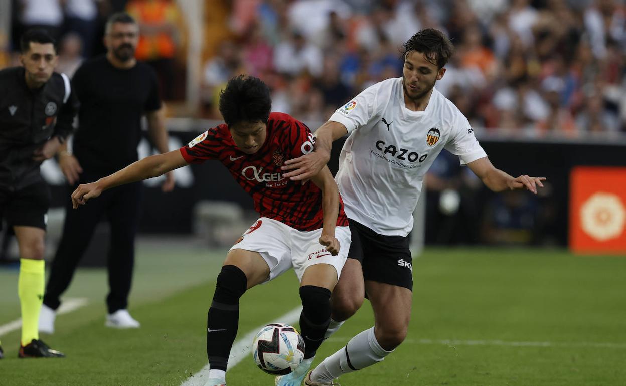 Nico González disputa con Kang In el balón en Mestalla.