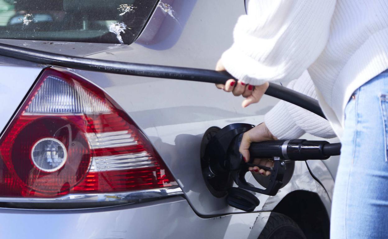 Una mujer echa gasolina en un autoservicio a su vehículo 