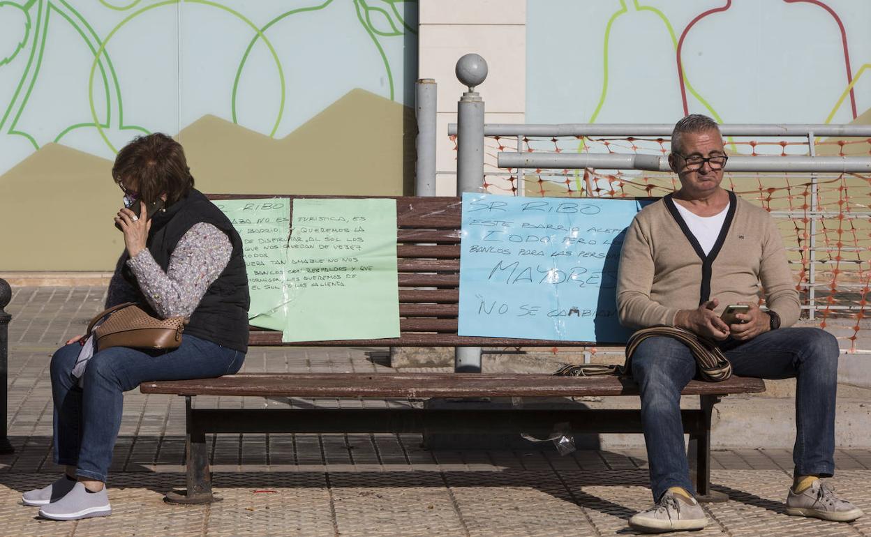 Dos vecinos del barrio de Exposición, sentados en un banco de la plaza Polo Bernabé.