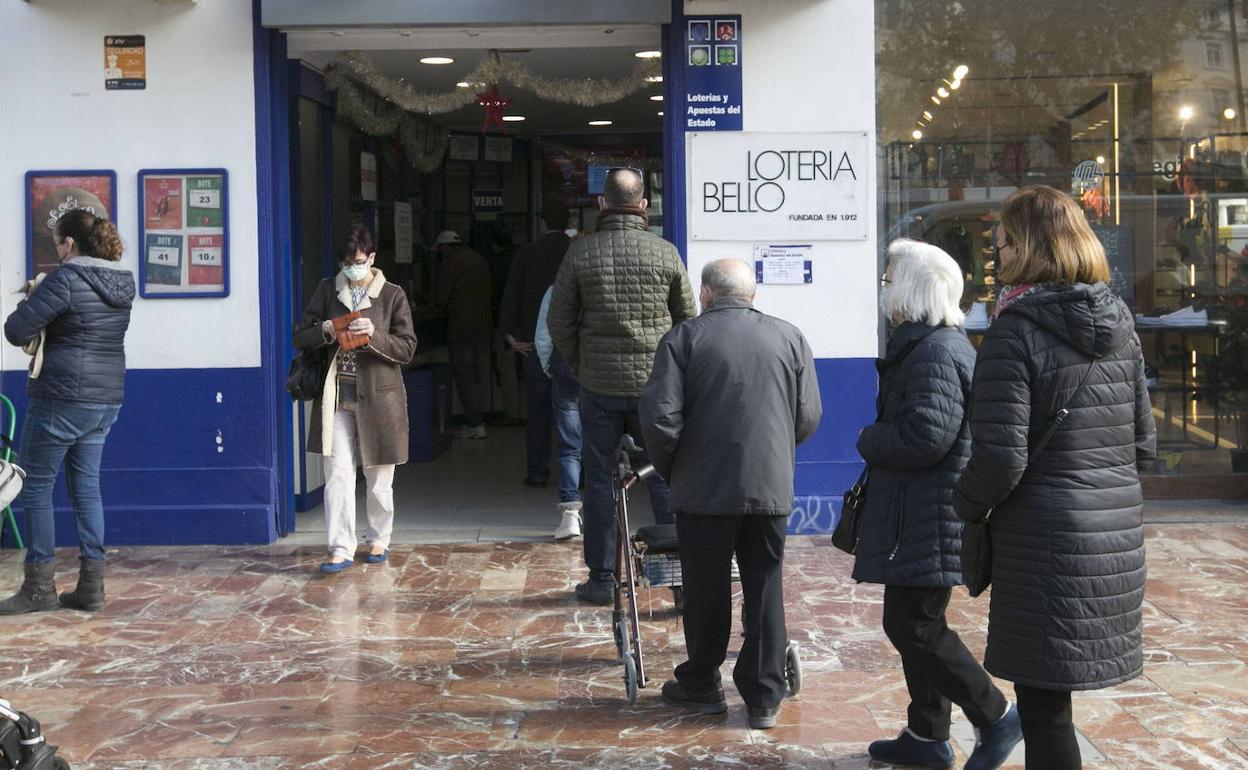 Varios clientes hacen cola ante una administración de lotería. 