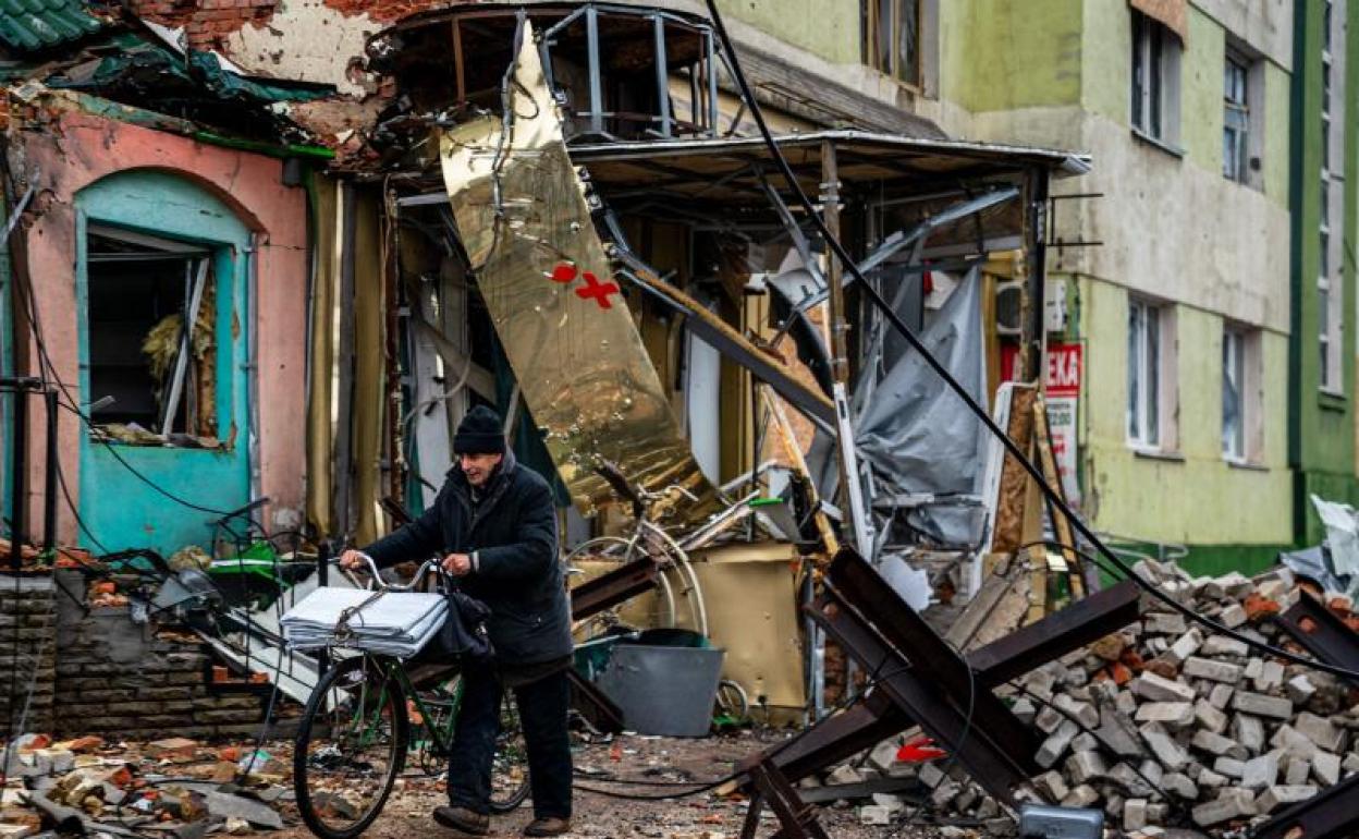 Un vecino de Bajmut atraviesa una calle destrozada por la batalla. 