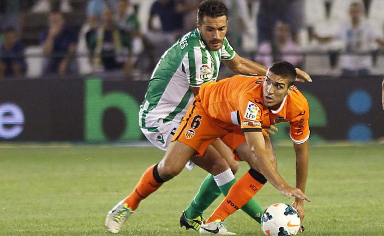 Xavi Torres encima a Oriol Romeu en un partido entre el Betis y el Valencia. 