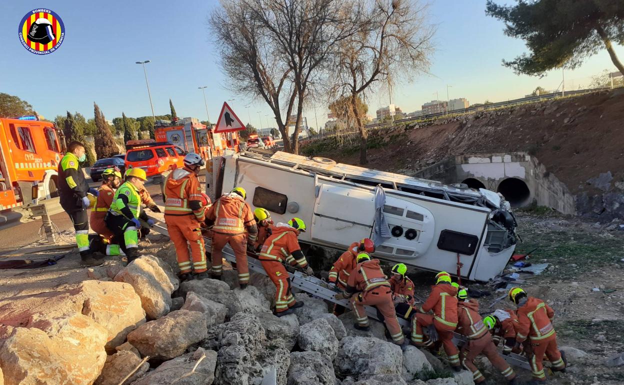 El autobús caído, durante las labores de rescate. 