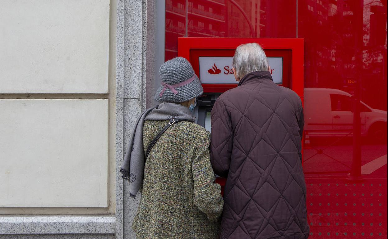 Una pareja lleva a cabo la retirada de efectivo en un cajero automático