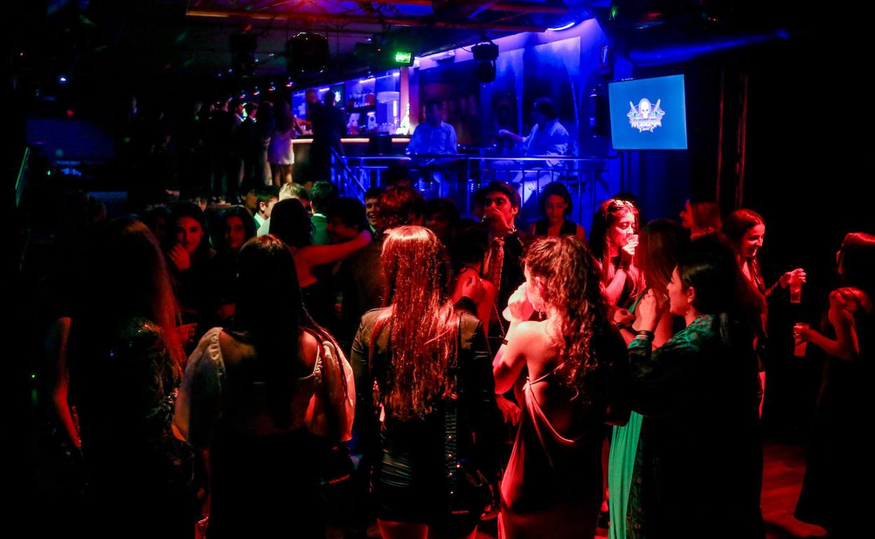 Varias personas bailan en una discoteca