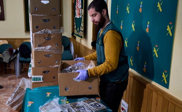 Un guardia civil levanta una de las cajas donde los narcos ocultaron la cocaína. 