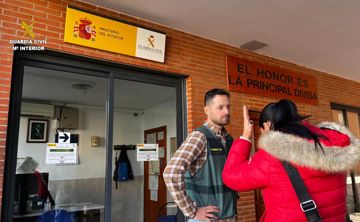 Un guardia civil atiende a una víctima en la puerta de un cuartel. 