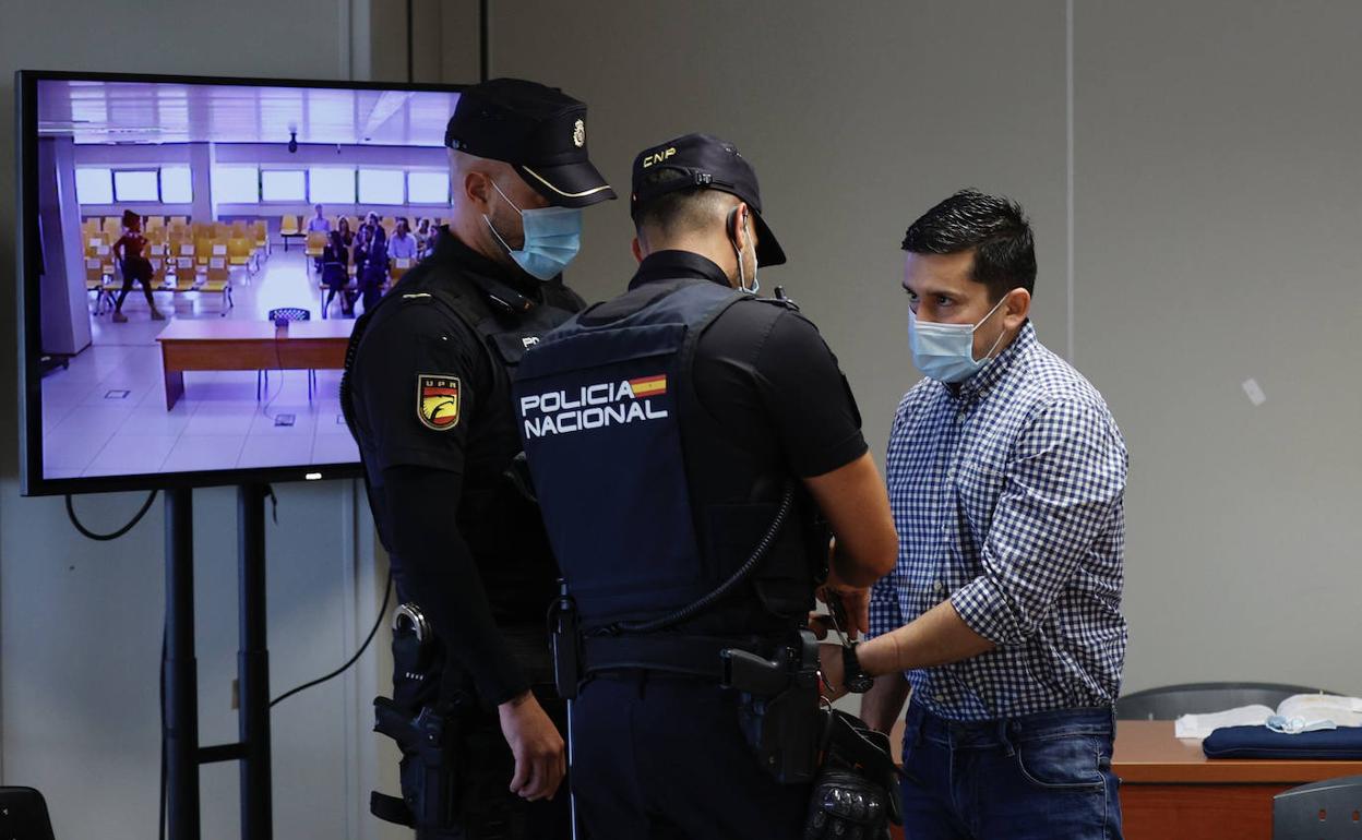 Dos policías nacionales junto al asesino Jorge Ignacio P. J., en una jornada del juicio en la Ciudad de la Justicia. 