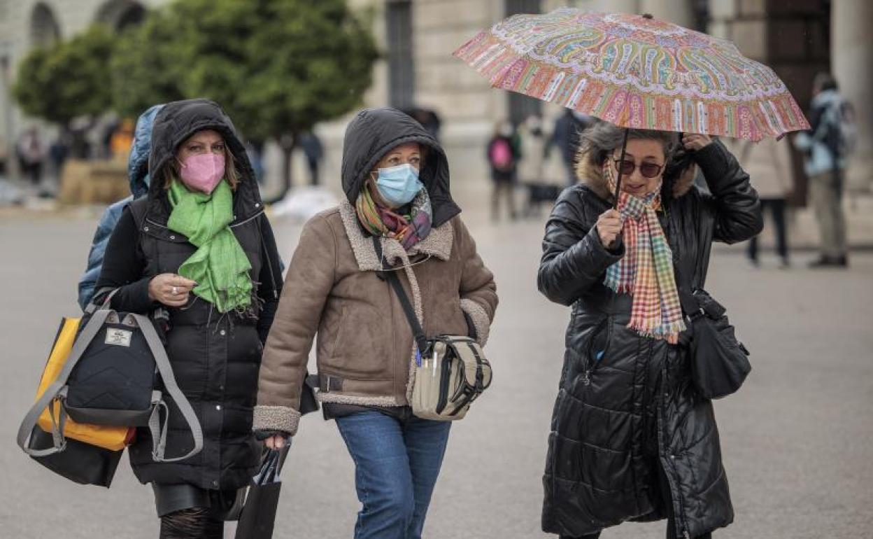 Un grupo de mujeres se protegen del frío. 