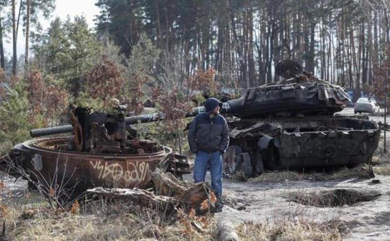 Un hombre observa blindados rusos destruidos a las afueras de Kiev