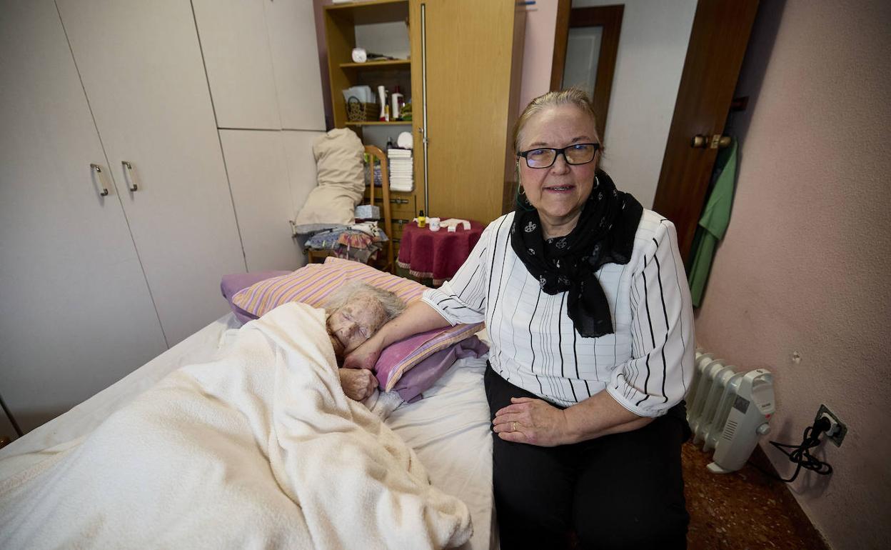 Lourdes sostiene la mano de su madre en su casa de Valencia. 