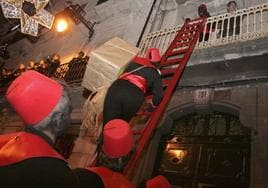 Pajes de los Reyes Magos suben a los balcones para entregar regalos durante la Cabalgata de Alcoi