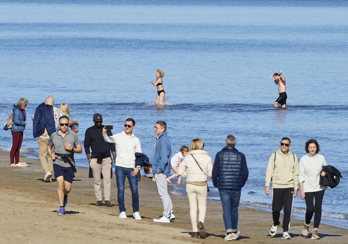 Varias personas paseando y bañándose en la playa de la Malvarrosa el pasado 1 de enero.