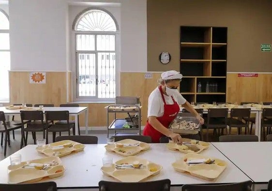 Una monitora prepara un menú en un colegio valenciano.