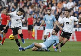 Unai Núñez defensa del Celta de Vigo cae ante Diego López y Hugo Duro, ambos del Valencia durante el partido correspondiente a la jornada 14 de LaLiga.