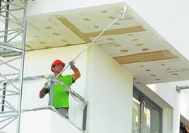 Un pintor profesional trabaja en la fachada de una vivienda.