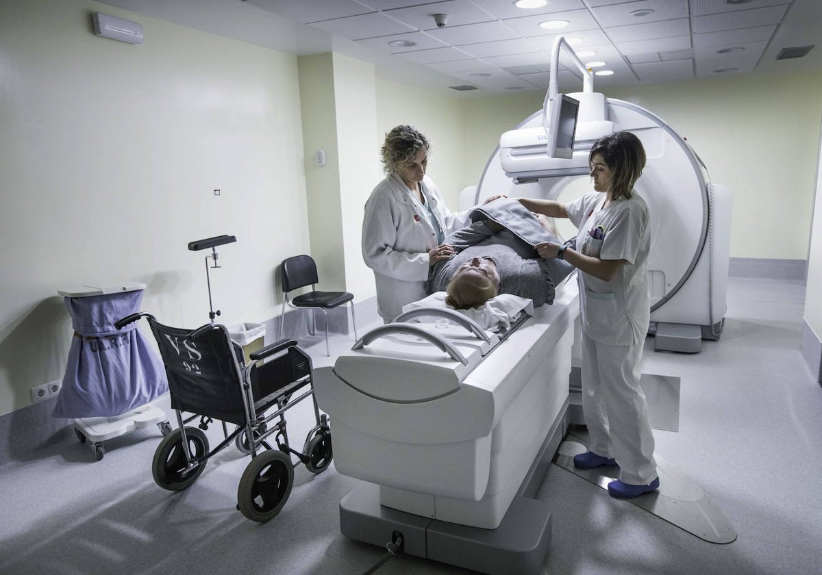 Dos sanitarios con un paciente en una prueba de medicina nuclear.