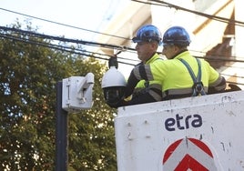 Dos operarios trabajan en el montaje de las cámaras en la calle Padre Viñas.