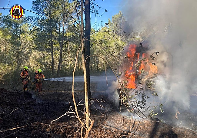 A la izquierda máquina que ha ardido y a la derecha dos efectivos apagando las llamas.
