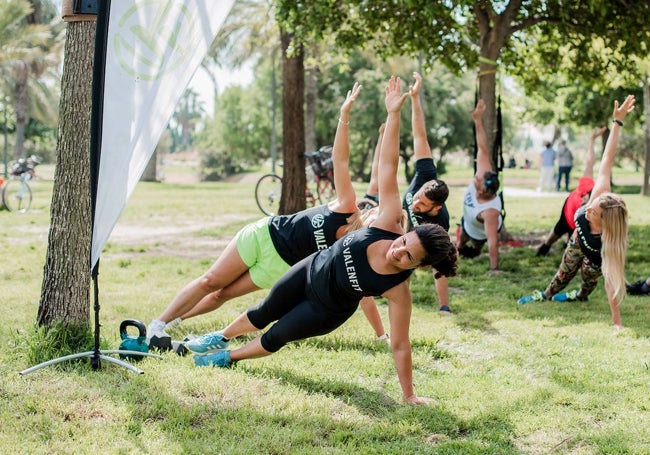 Usuarios de Valenfit realizan una plancha lateral.