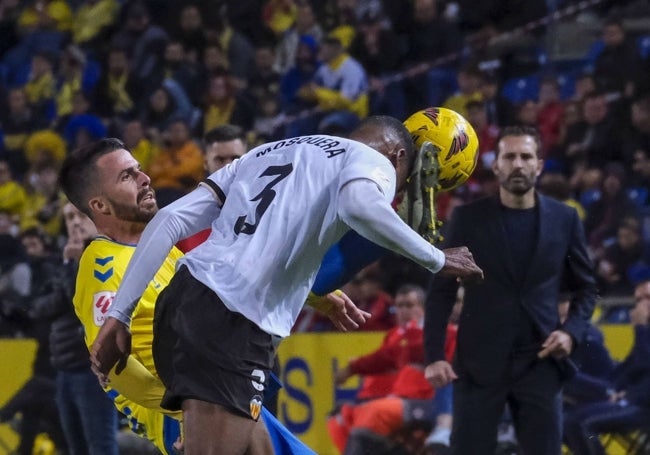 Mosquera despeja un balón ante la atenta mirada de Rubén Baraja.