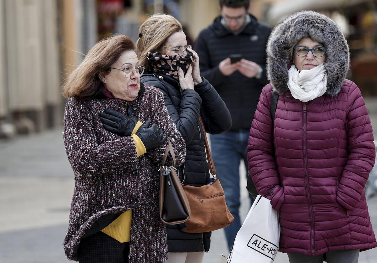 Tres mujeres protegidas contra el viento y el frio pasean por el centro de Valencia en una imagen de archivo.