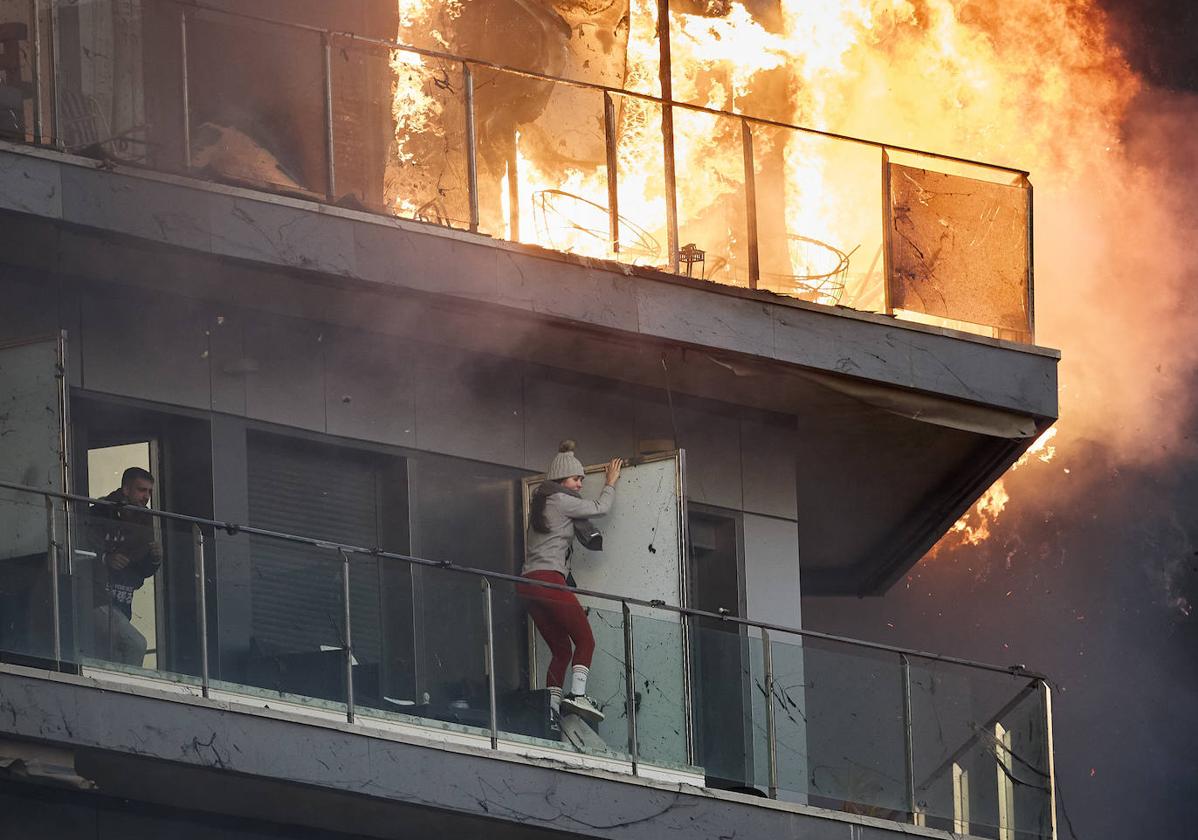 Dos personas, atrapadas en uno de los balcones del edificio en llamas.