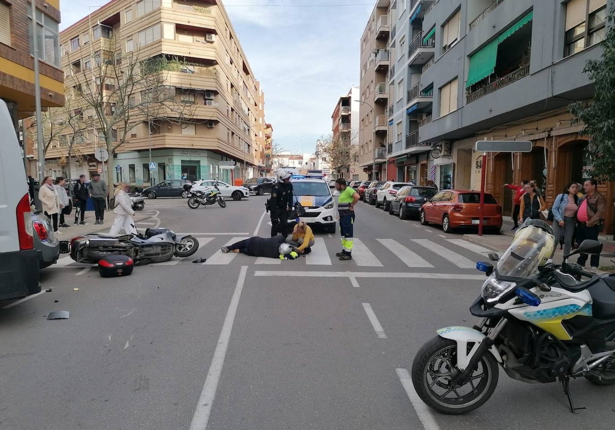 Un agente junto al motorista herido mientras espera la llegada de la ambulancia.