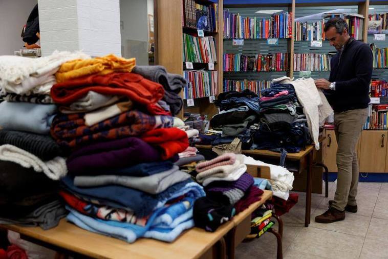 Una persona recoge ropa para los evacuados.