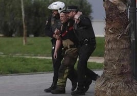 Dos policías locales auxilian a uno de los bomberos heridos.