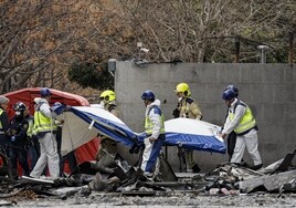 Agentes de Policía Científica y bomberos cubren el cuerpo del último cadáver hallado.