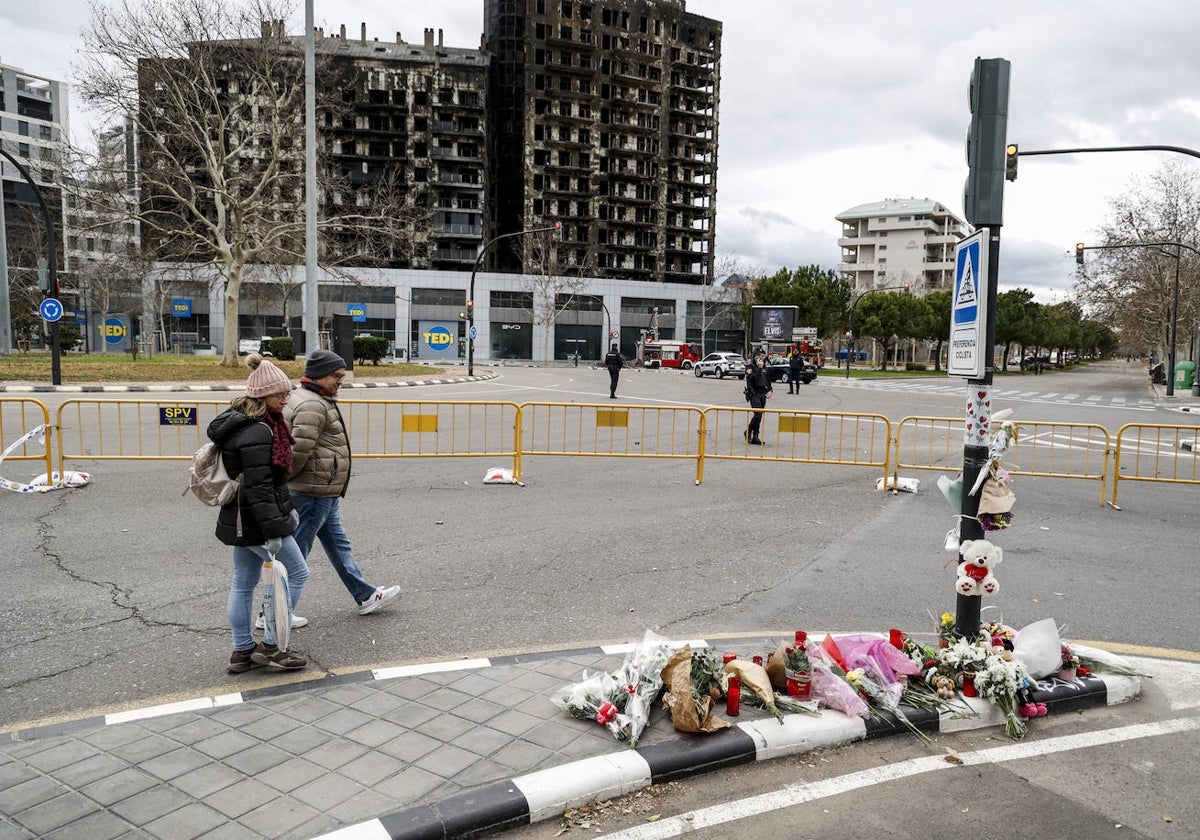 Flores, juguetes, peluches y velas en el altar improvisado cerca del edificio.