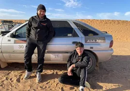 Dani Física y Adrián Garrido, con su coche, en el desierto.