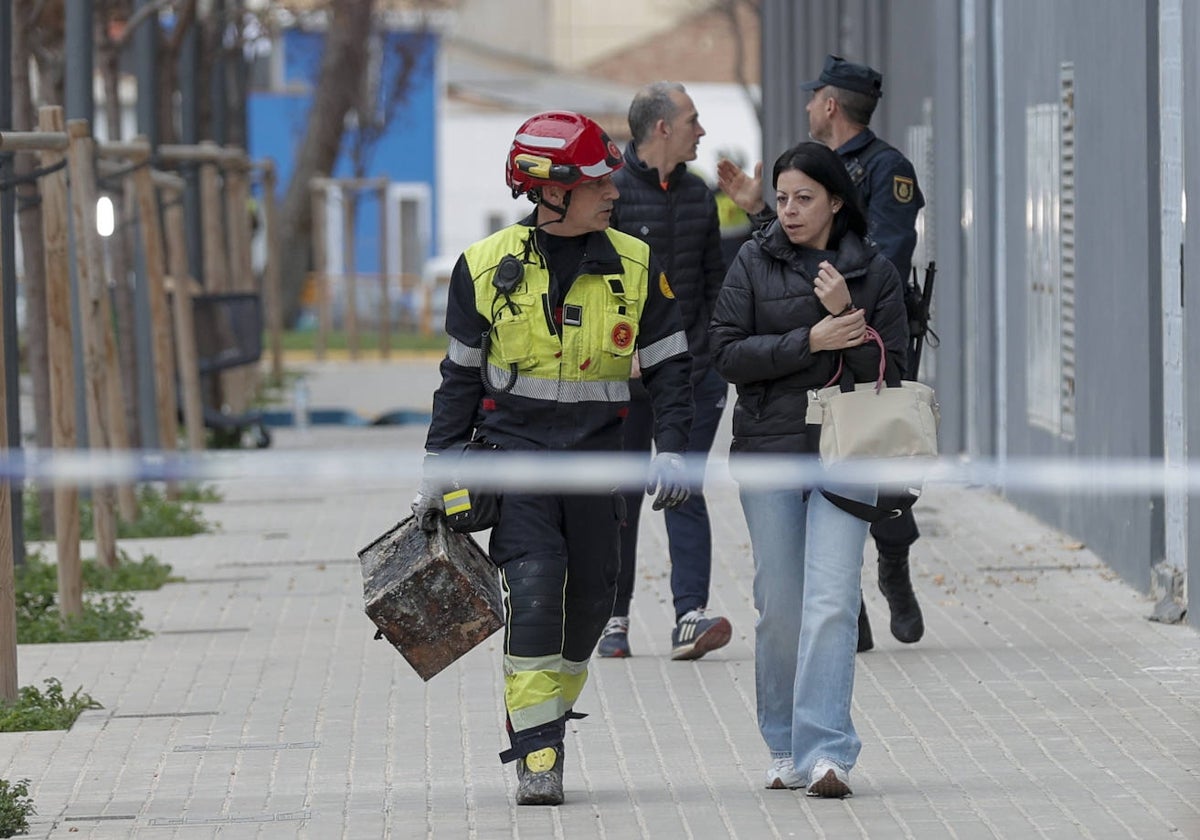 Un bombero acompaña a una vecina con sus pertenencias.