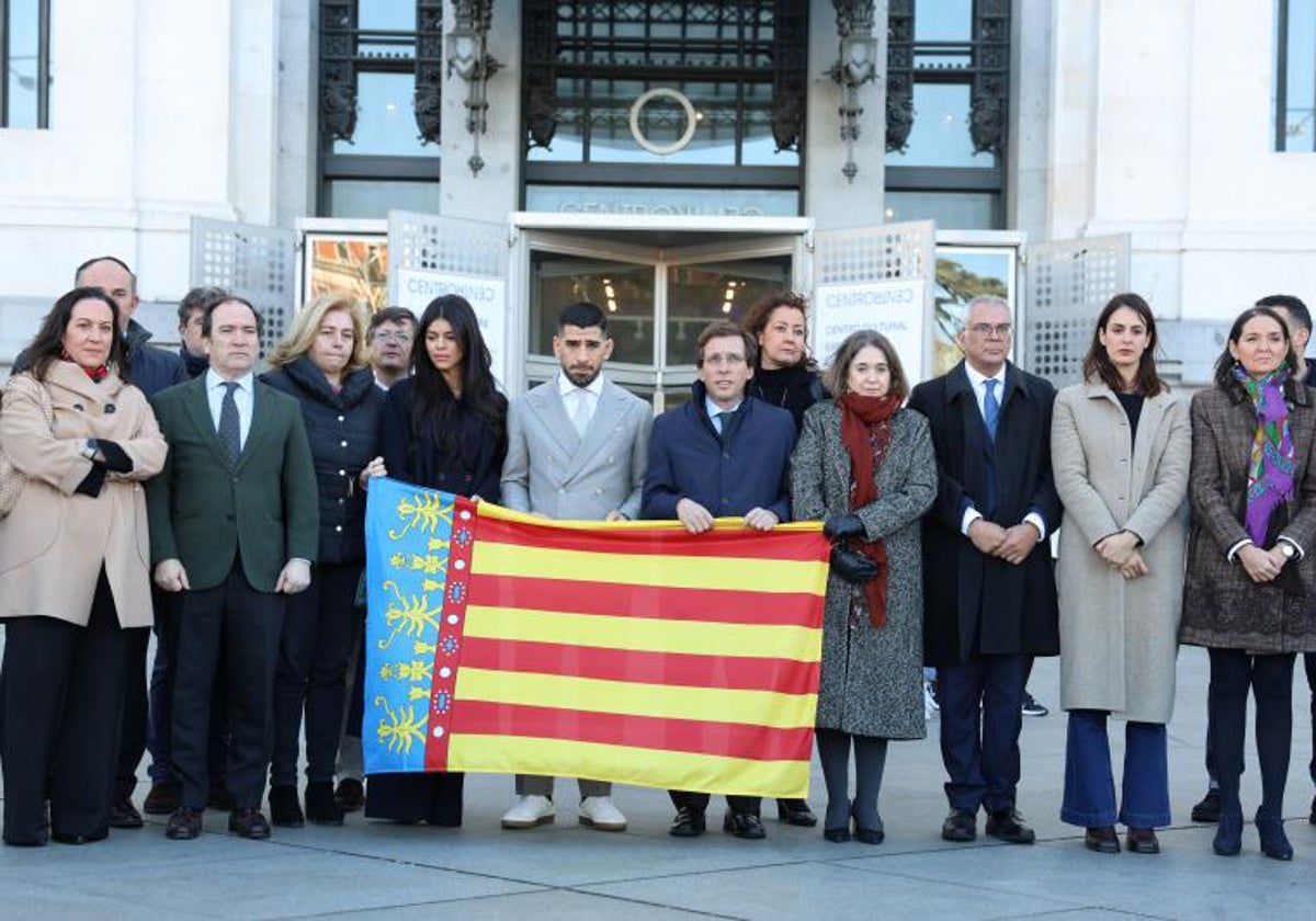 Topuria sostiene en el centro una Senyera durante el minuto de silencio en Madrid por las víctimas de Campanar.