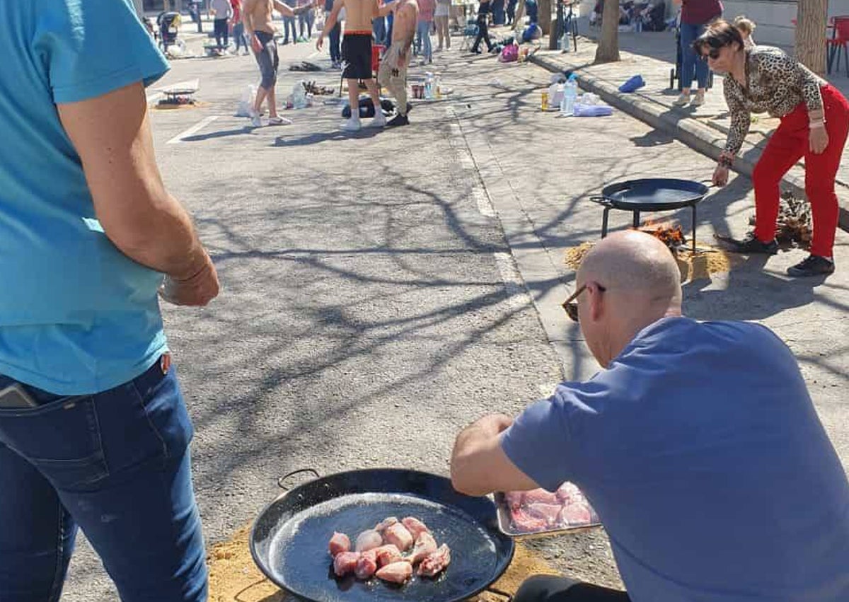 Imagen secundaria 1 - Cartel de la paella solidaria con los establecimientos donde se pueden comprar las raciones y concurso de paellas de La Nova de Campanar, el pasado año.