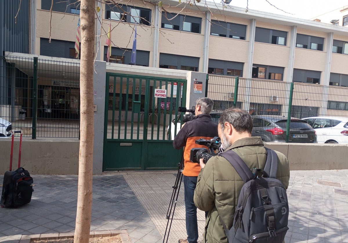 Dos reporteros gráficos graban imágenes en la puerta del instituto de Xirivella.