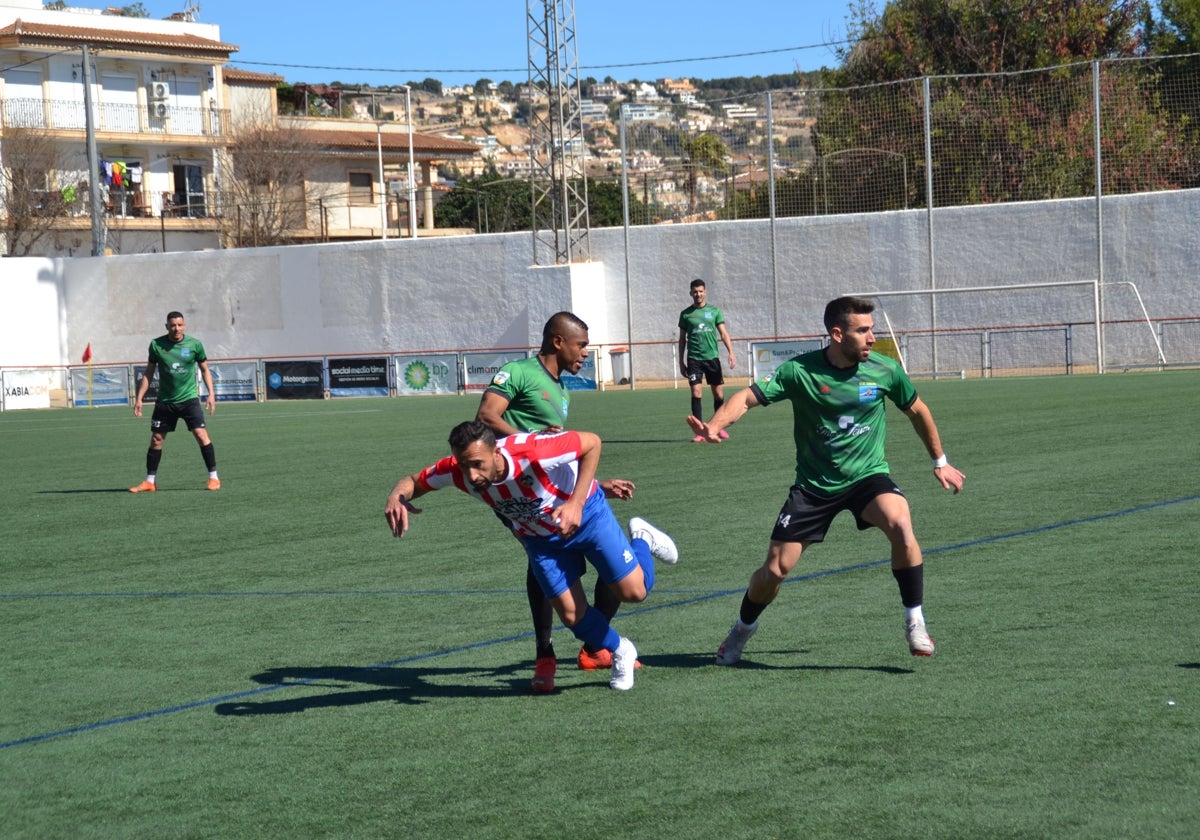 Dos jugadores de la UD Calpe ante uno del Jávea.