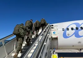 Militares embarcando en un avión.