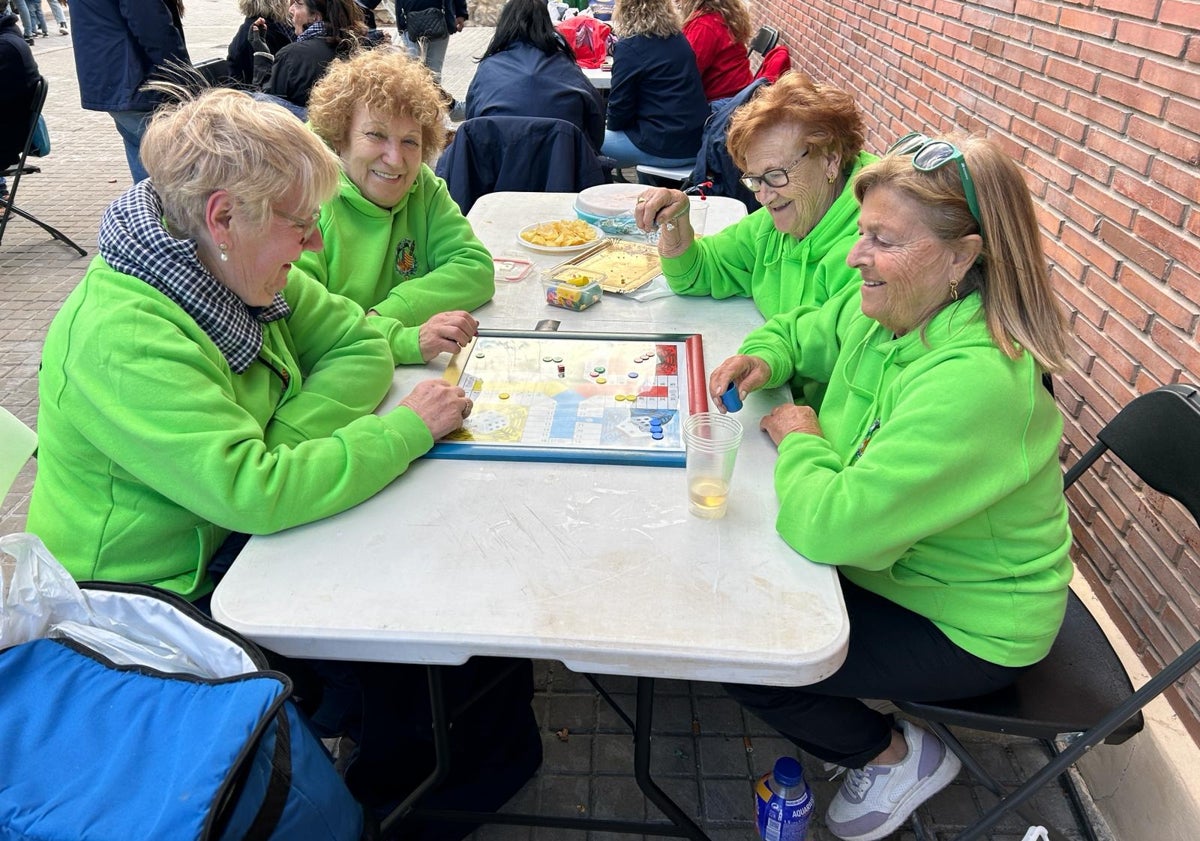 Imagen principal - Las chicas de oro de la falla Peset juegan una partida de parchís.